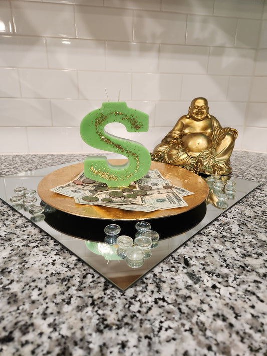 Dollar Sign Candle sitting on money surrounded with rhinestones and Buddha