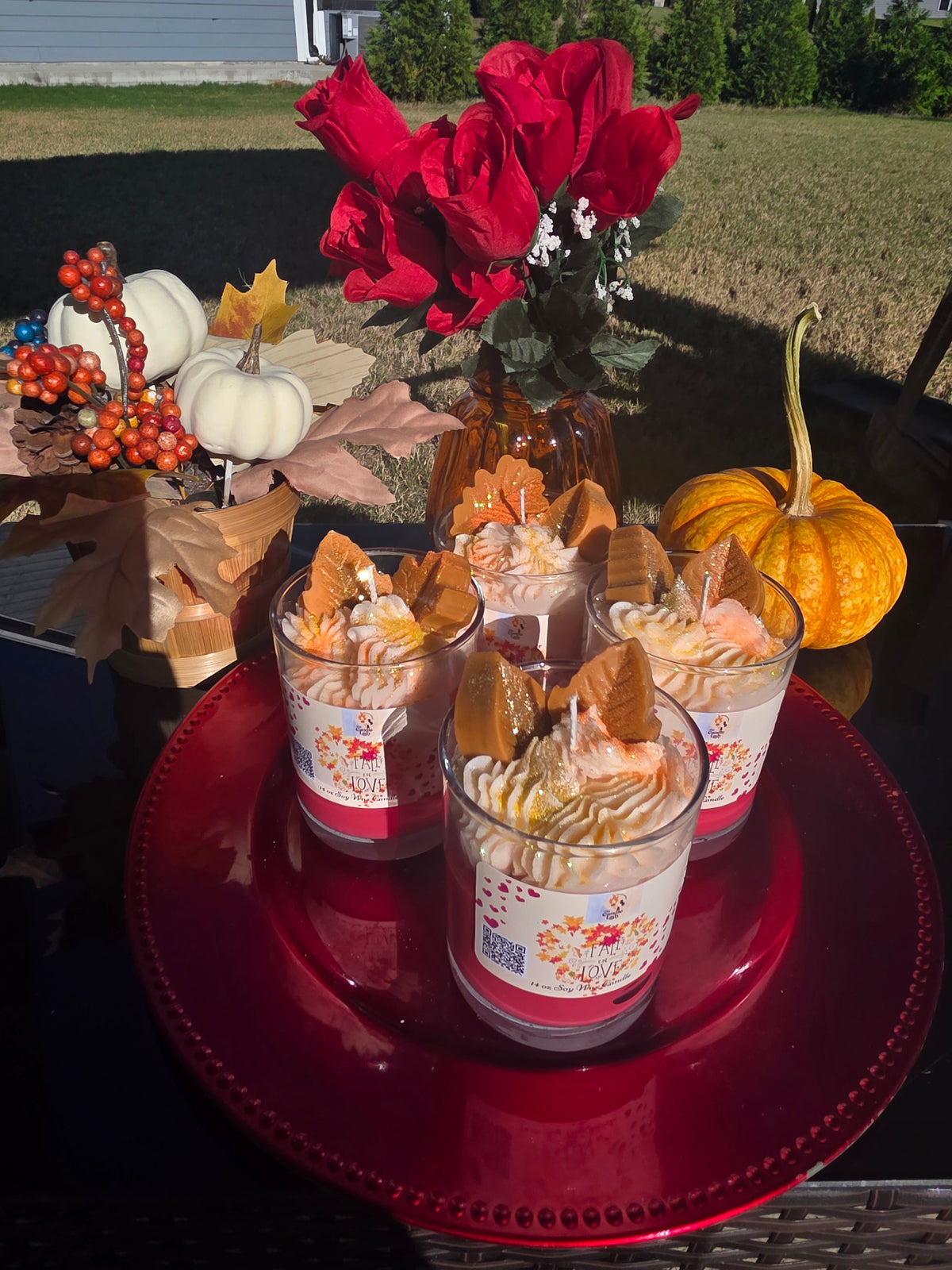 Two fall themed candles on a red plate with pumpkins and flowers in the background