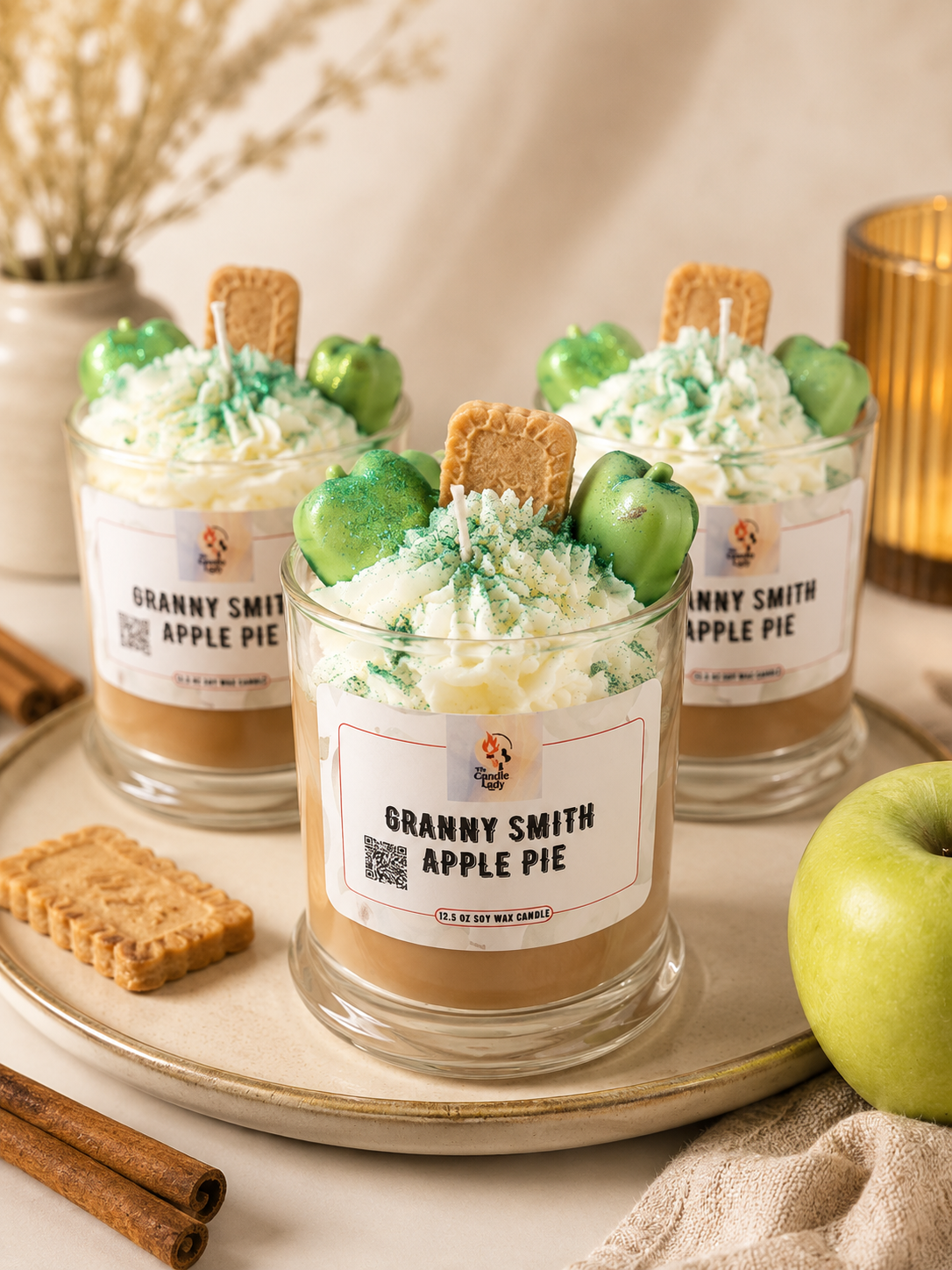 Apple pie candles sitting on a plate next to Apple decorations