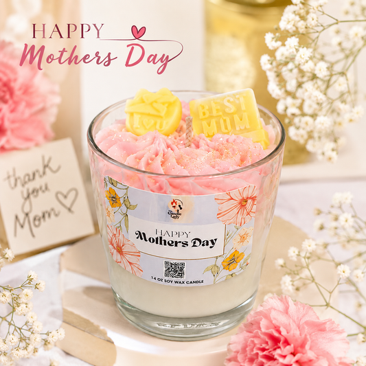 Candle with a 'Happy Mothers Day' label surrounded by flowers and a card on a light background