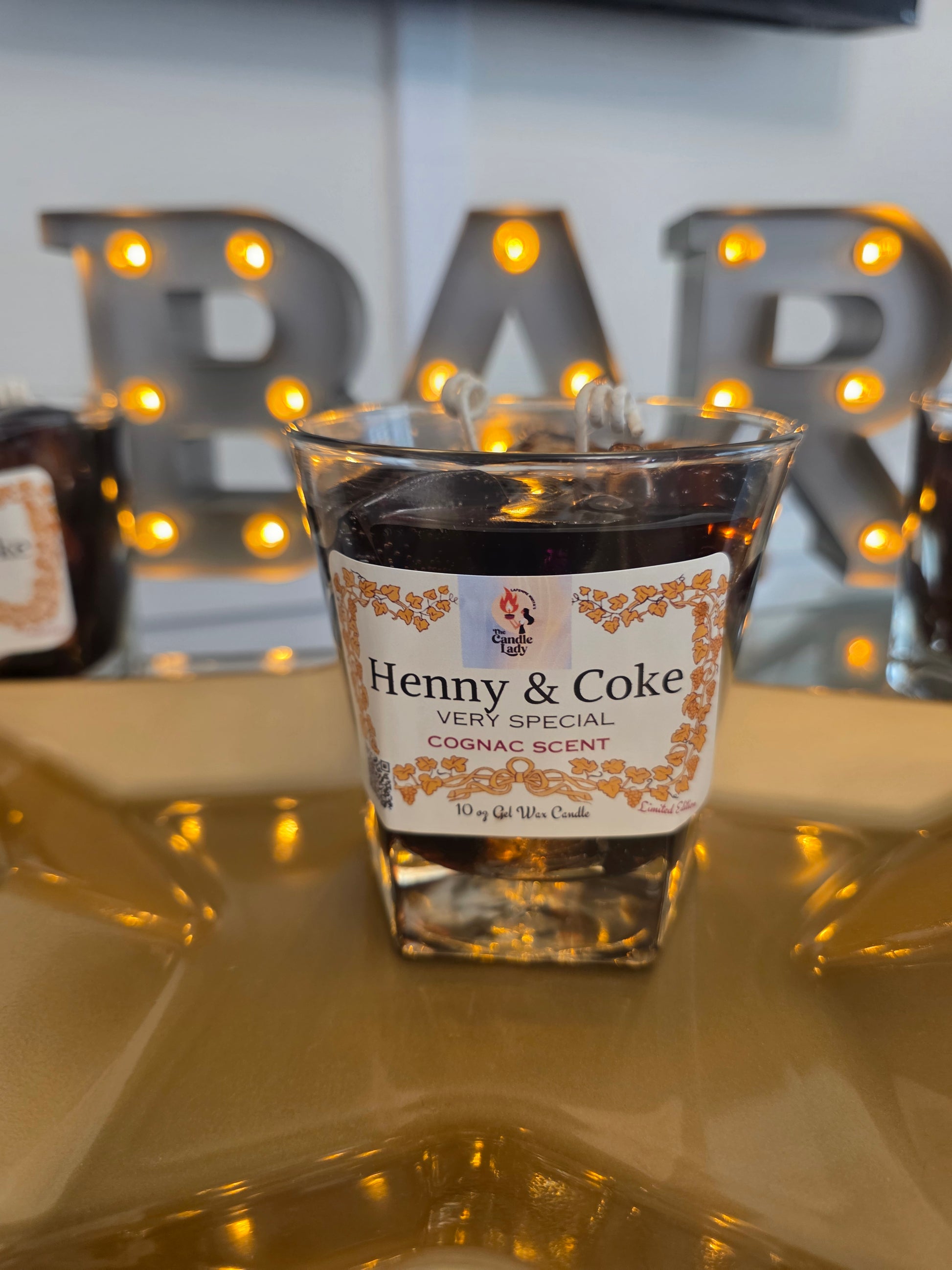Henny & Coke Wax candle
 with decorative lights in the background