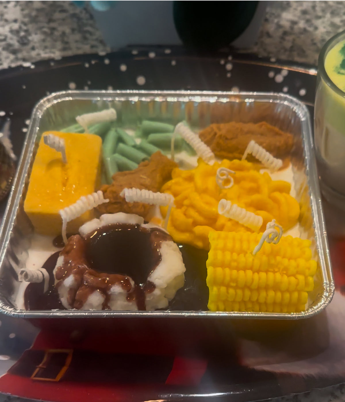 Food dinner tray made of soy wax in a tin container on a table