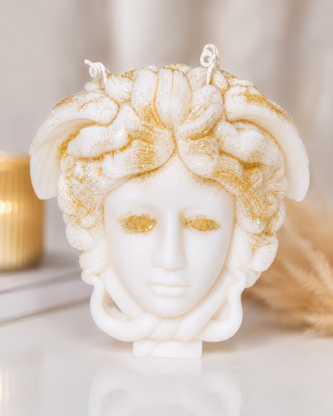 Medusa head Versace themed pillar candle sitting on the table