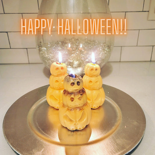 Three small Halloween-themed candles on a stand with 'Happy Halloween!!' text above.
