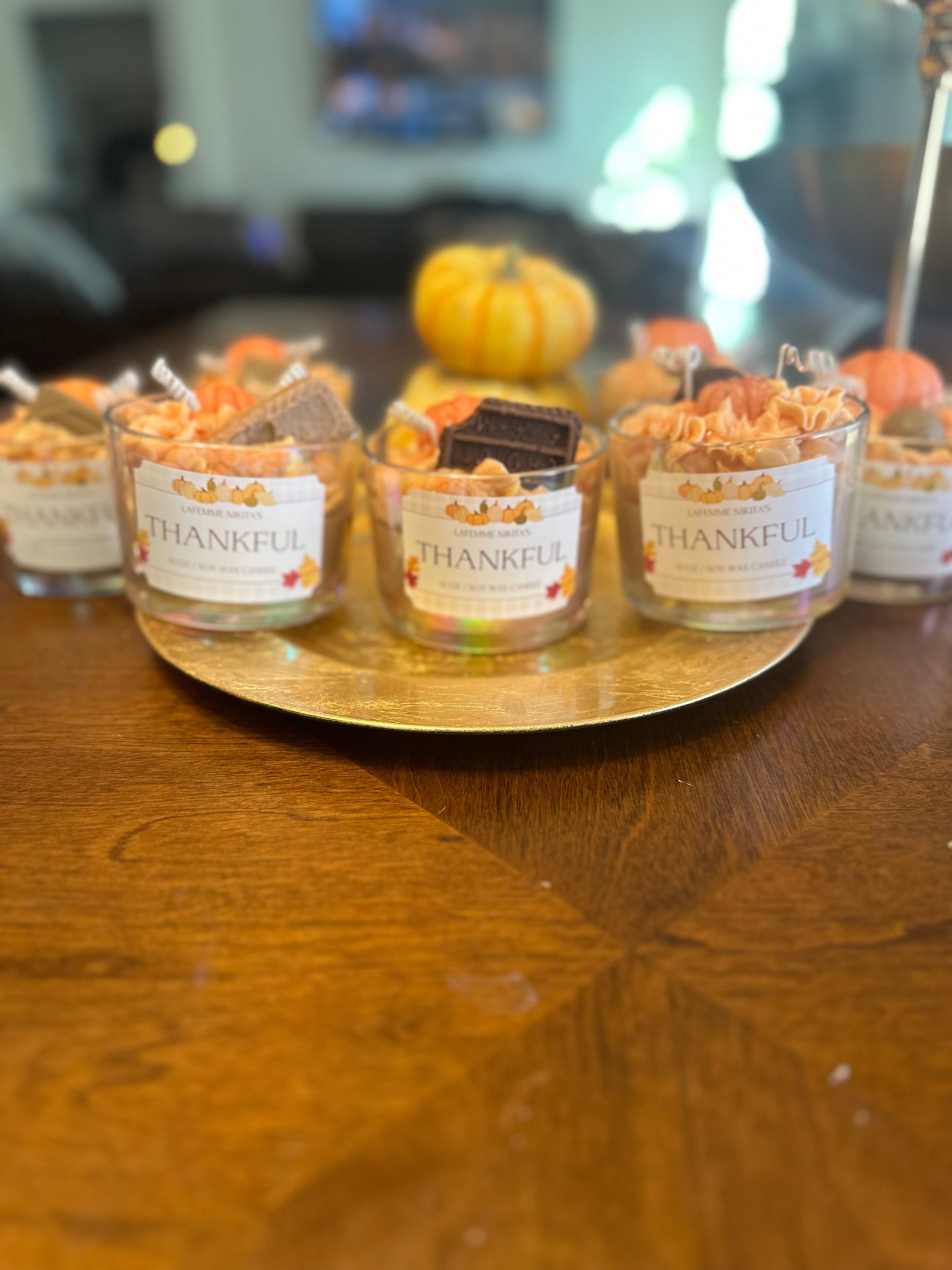 Thanksgiving inspired candles labeled Thankful sitting on a tray on the table