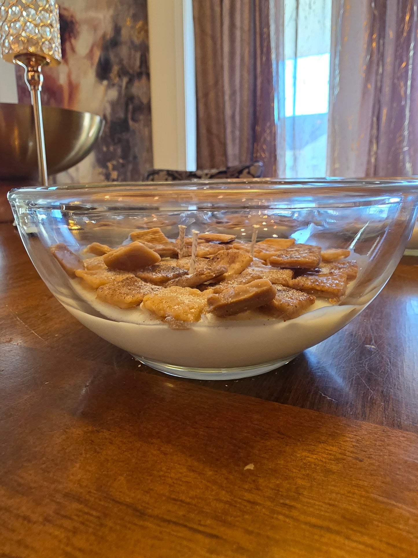 Glass dish with cinnamon toast crunch cereal candle on a wooden surface