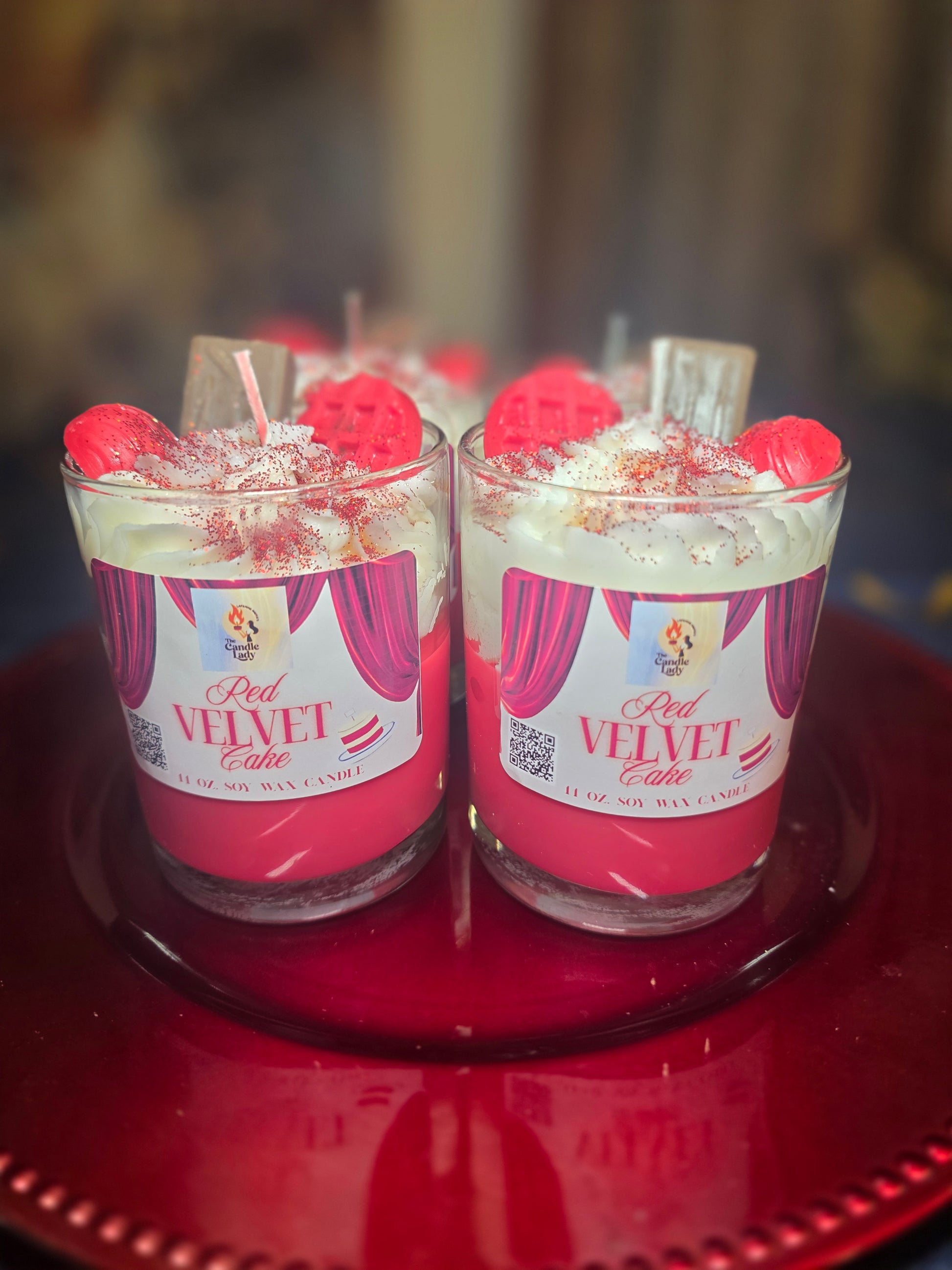 two red velvet cake candles on a red platter