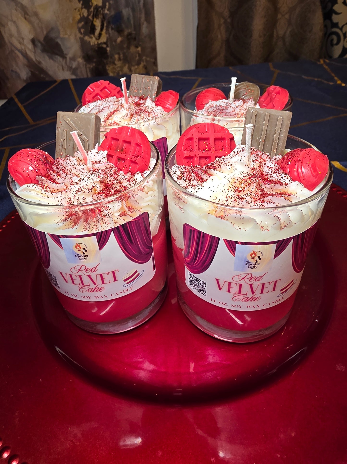 two red velvet cake candles on a red platter
